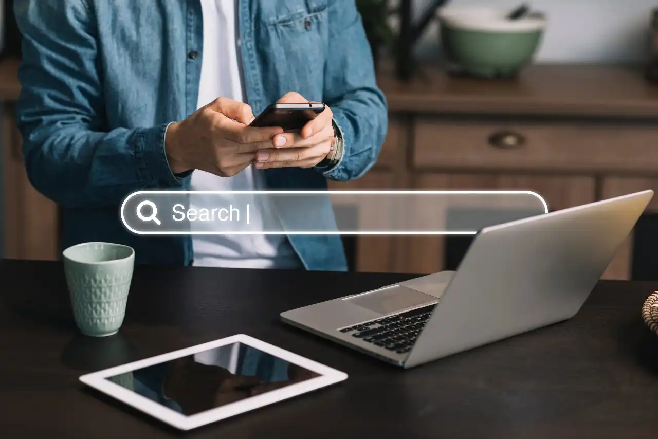 Person searching online for the best cannabis SEO companies using smartphone and laptop