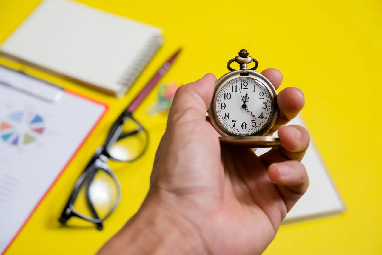 close up on hand holding a clock