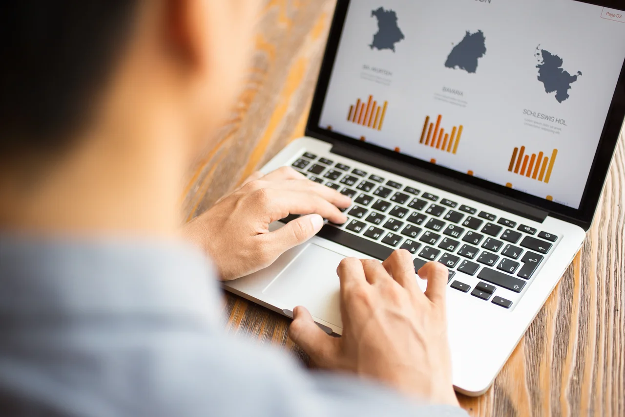 Analyzing data and developing business strategy on a laptop.